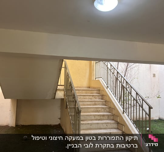 גרם מדרגות עם מעקה מתכת ותאורה עליונה